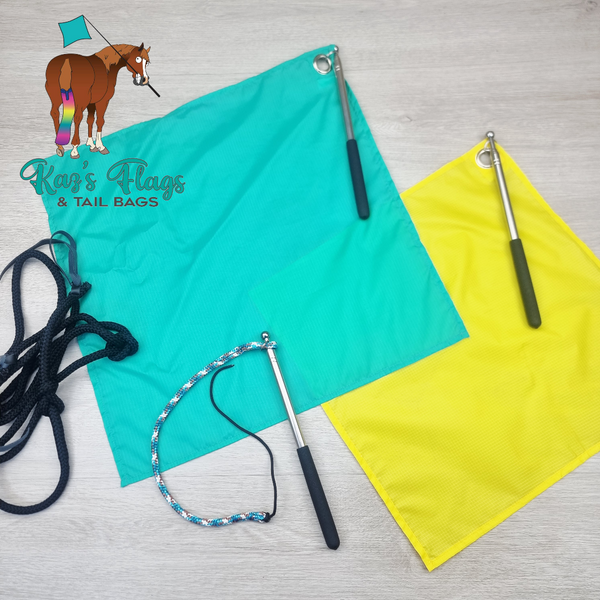 Two rectangular tail flags in bright turquoise and yellow, each with a metal grommet and attached pole, plus two rope tails and a small horse-and-flag logo watermark reading 'Kaz's Flags & Tail Bags' on a light wood surface.