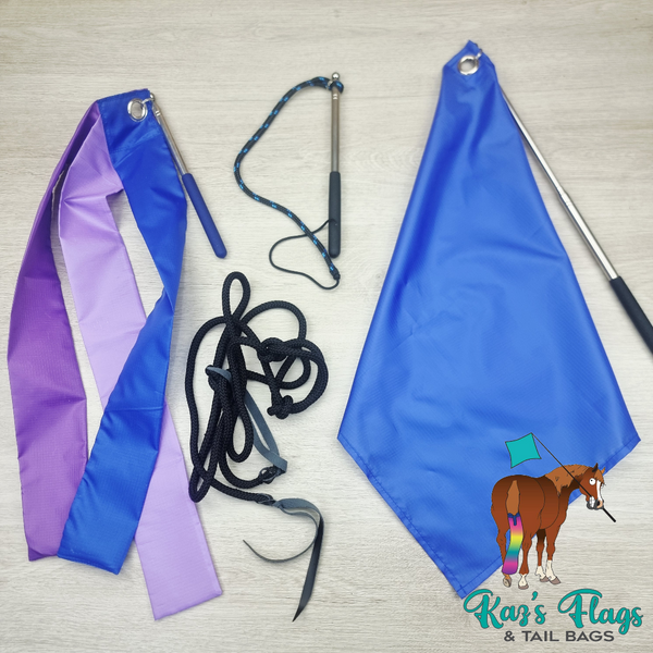 A set of equestrian tail flags and reins laid out on a light wood background, including a blue and purple ribbon flag, a blue flag with a silver pole, black reins, and a blue-and-black lead. The 'Kar's Flags & Tail Bags' logo is visible in the bottom right corner.