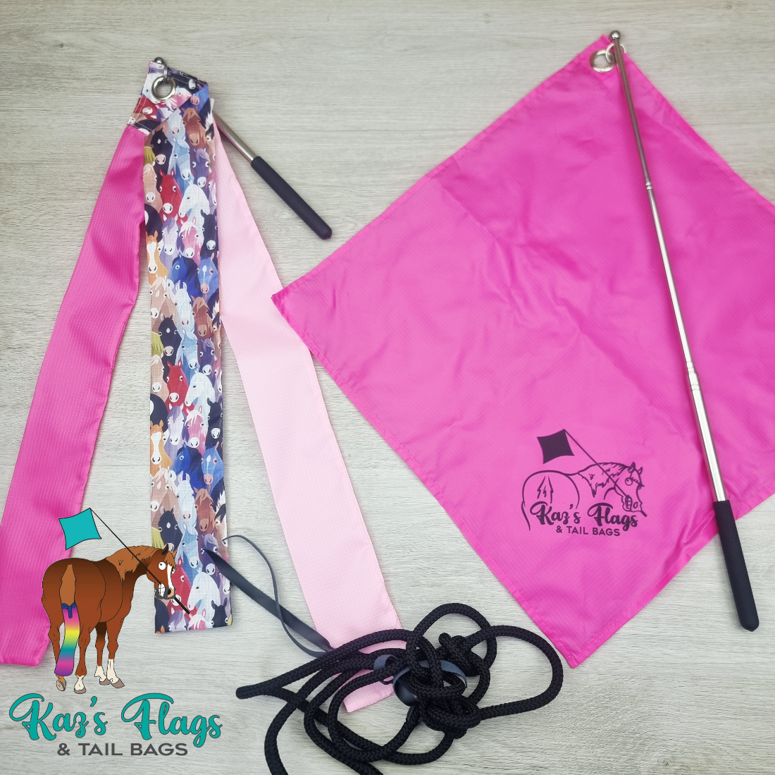 A flat-lay product display of an equestrian tail bag set by Kari's Flags & Tail Bags, featuring a bright pink flag, a patterned pink and multicolor tail strap, a black rope, and a silver telescopic pole on a light wood background.