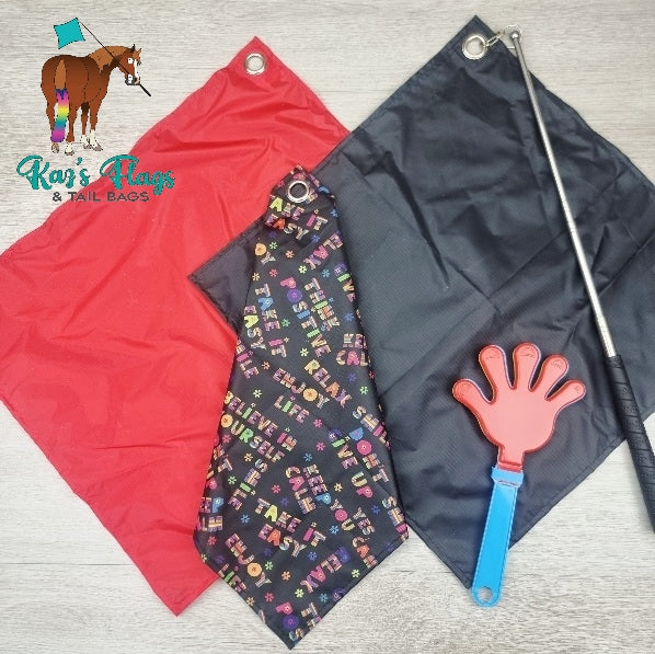 Three colorful Flags and a hand-shaped clapper on a wooden surface with 'Kaz's Flags & Tail Bags' branding.