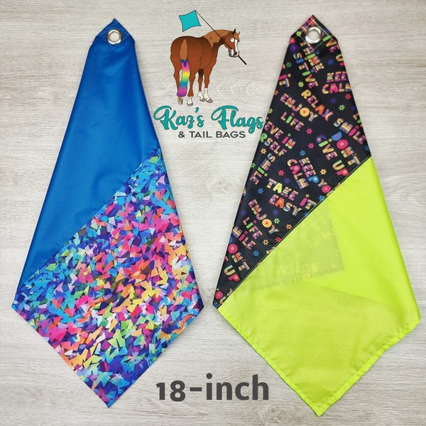 Two colorful flags with text and patterns, branded 'Kaz's Flags & Tail Bags', on a wooden surface.