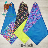 Three colorful flags with text and patterns on a wooden surface, featuring the brand 'Kags Flags & Tail Bags'.