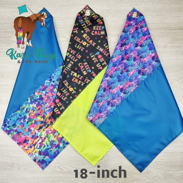 Three colorful flags with text and patterns on a wooden surface, featuring the brand 'Kags Flags & Tail Bags'.