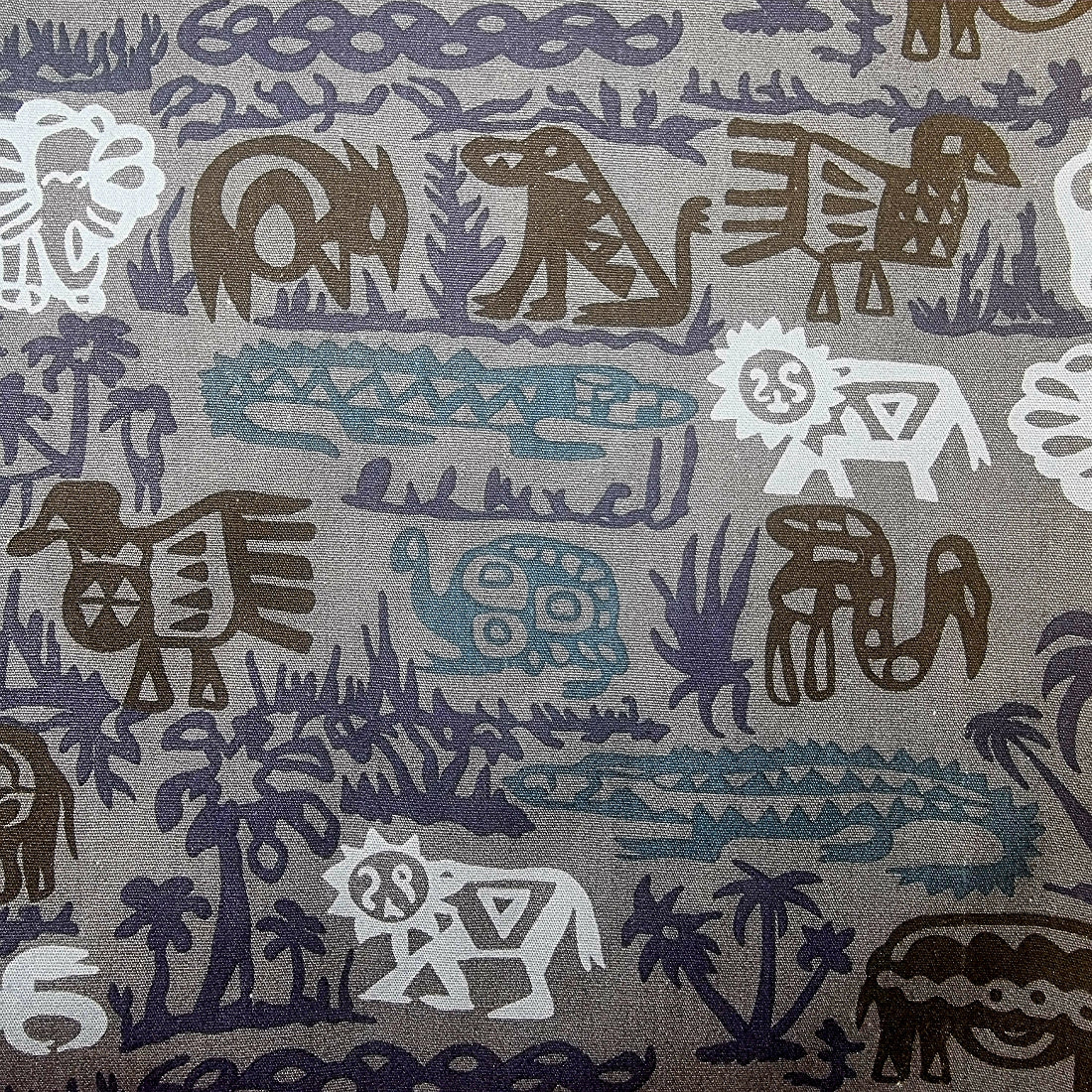 Patterned fabric with animal and nature designs in brown, blue, and light grey on a grey background.