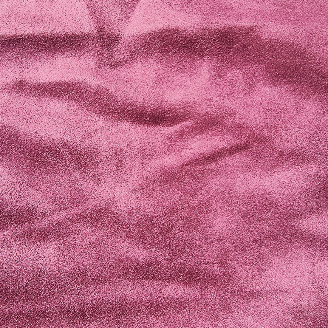 A close-up of textured maroon fabric with a soft, slightly mottled surface and gentle folds.