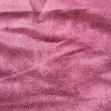 A close-up of textured maroon fabric with a soft, slightly mottled surface and gentle folds.