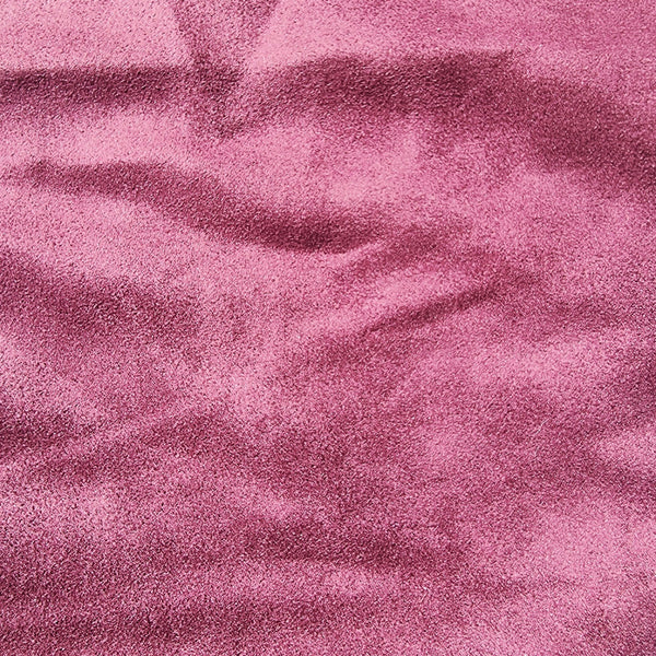 A close-up of textured maroon fabric with a soft, slightly mottled surface and gentle folds.