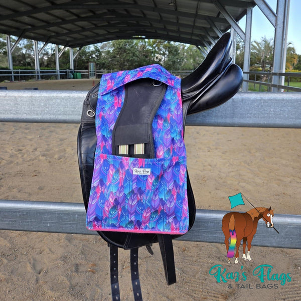 Colourful Stirrup and Girth Holder sitting over a saddle in an outdoor equestrian setting.