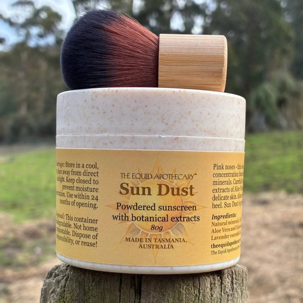 Sun Dust powdered sunscreen with botanical extracts on a wooden surface outdoors